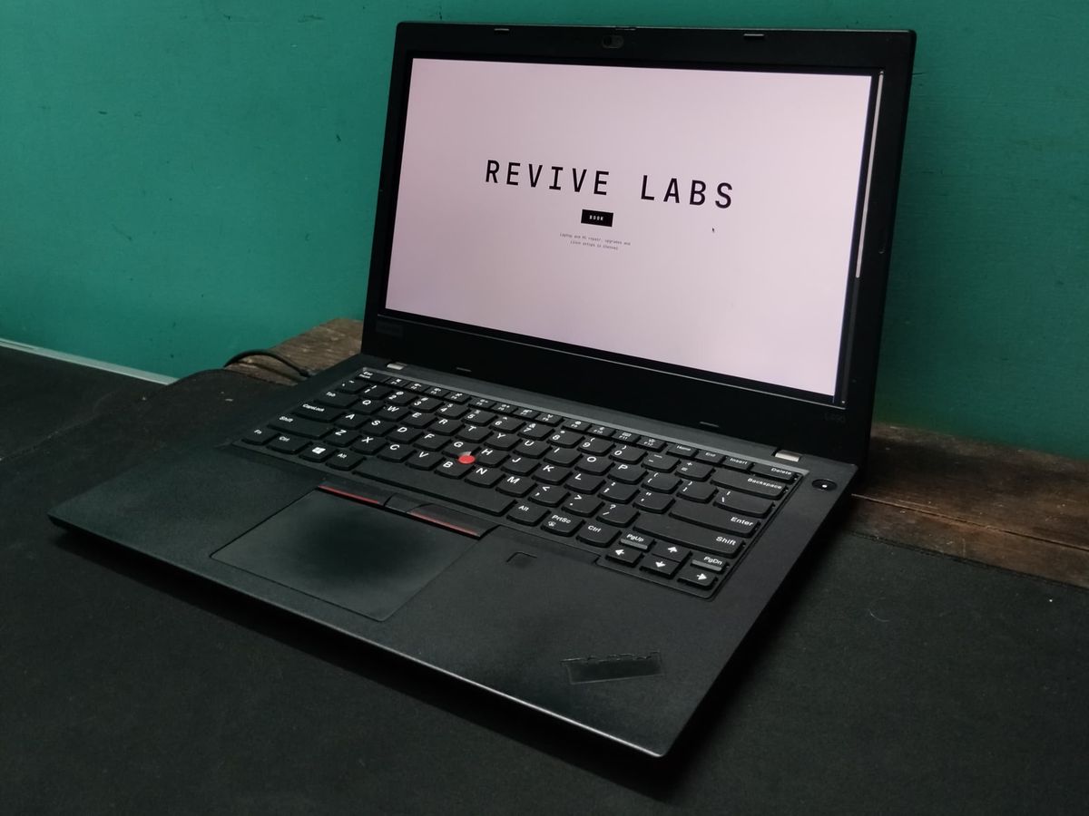A thinkpad sitting open on a table, showing the Revive Labs website