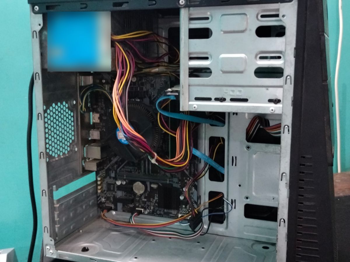 Inside of a PC tower with the side panel off, showing the motherboard, cooler and cables